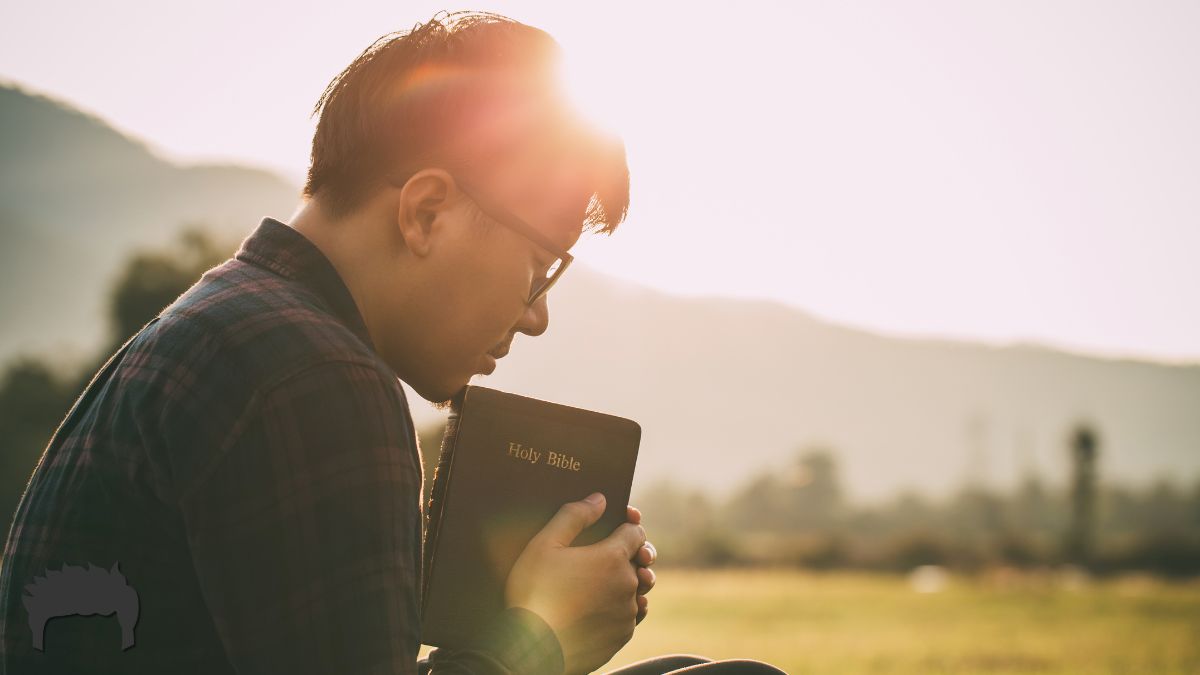 Christian man holding a Bible with sunlight.