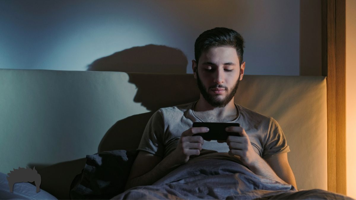 A man in bed, watching YouTube.