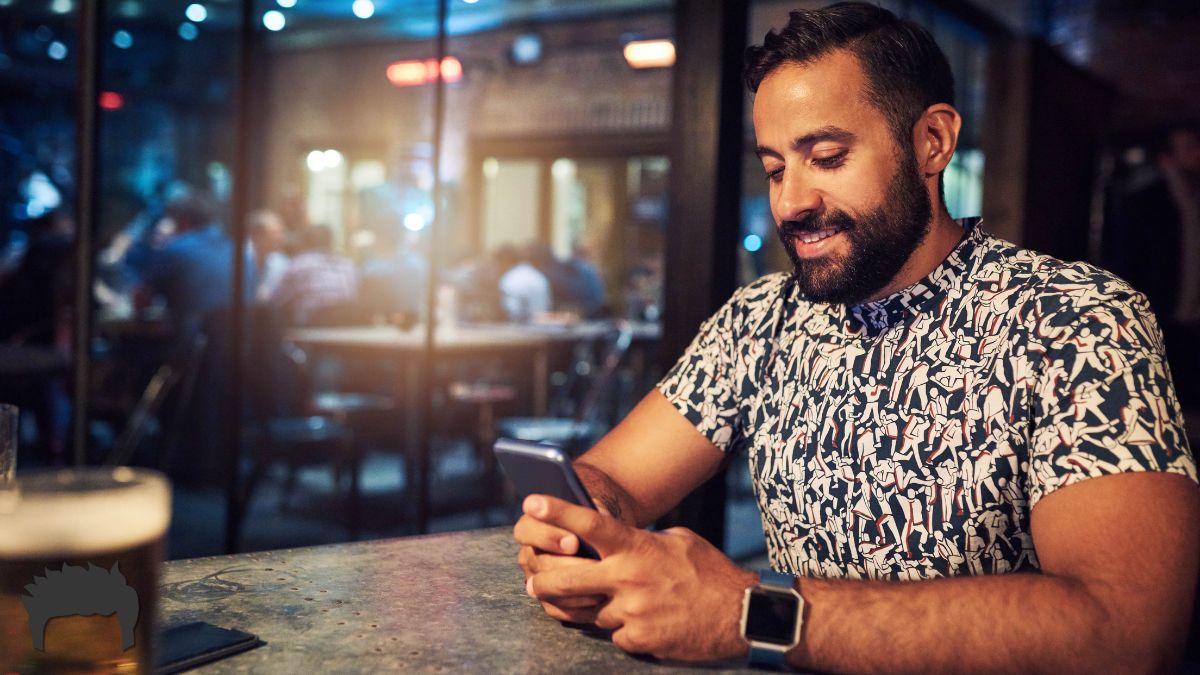 Man sits looking at his phone on social media.