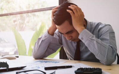 A man sitting at his desk, overworked.